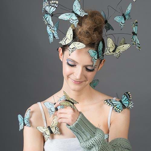 Hairdressing student covered in faux butterflies 