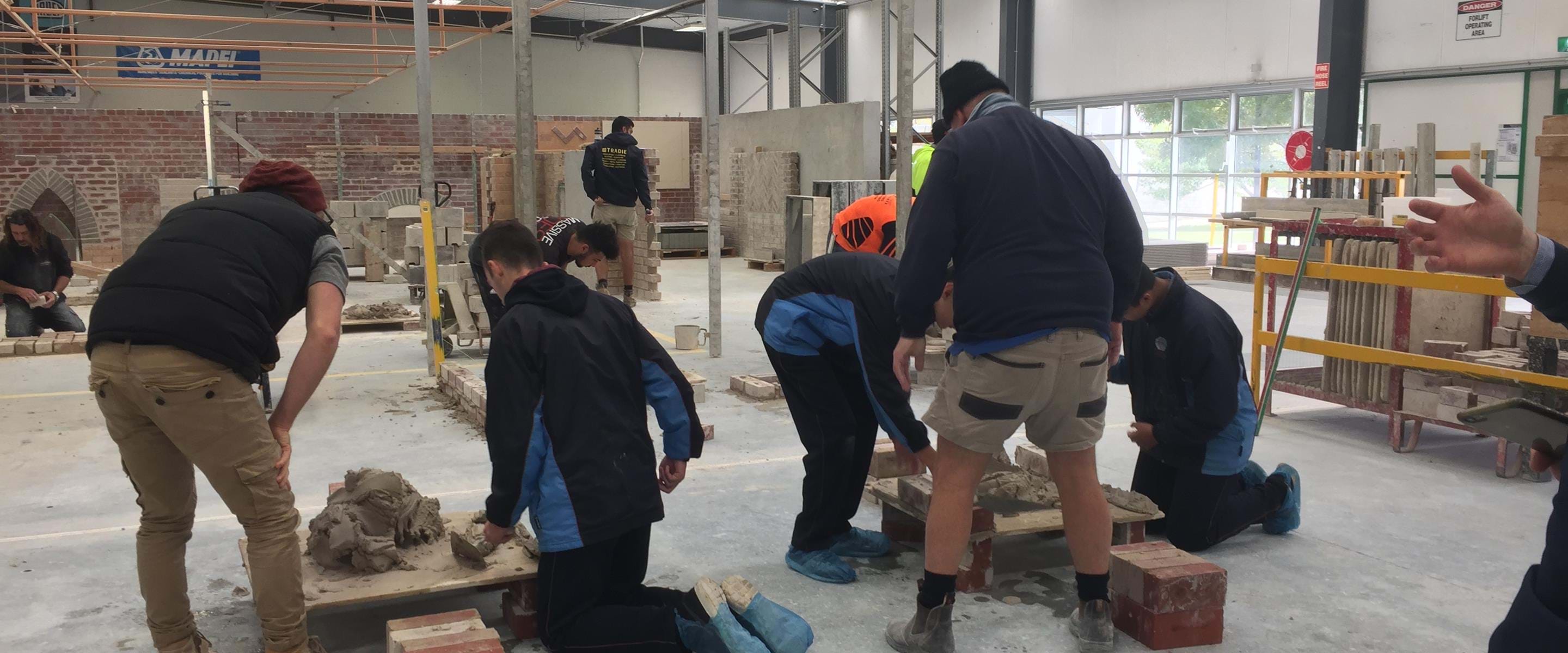 Melbourne Polytechnic Bricklaying students with concrete mix and brick stacks
