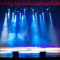 A bare stage with spotlights coming down
