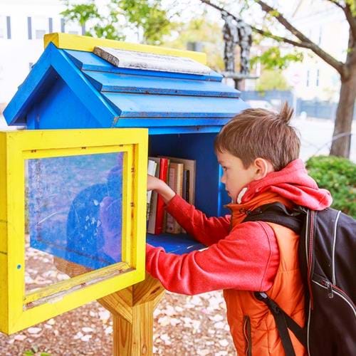 Image of child exchanging books at street library box